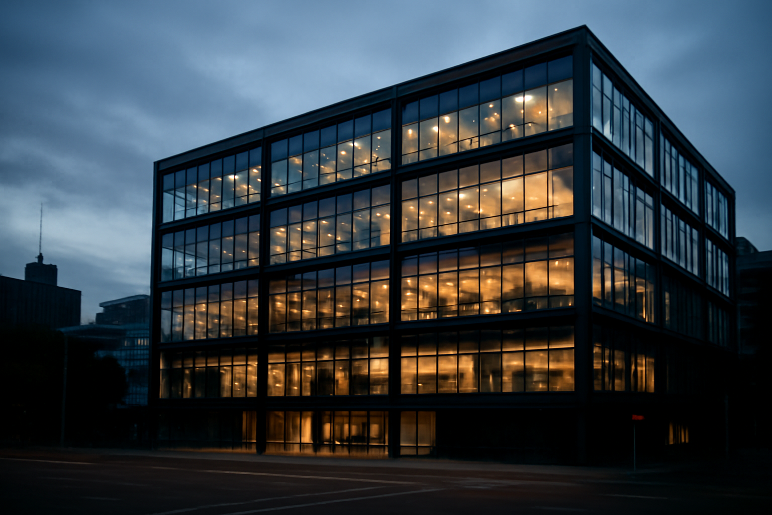 Exterior of a modern Australian corporate media office building with glass facade at dusk