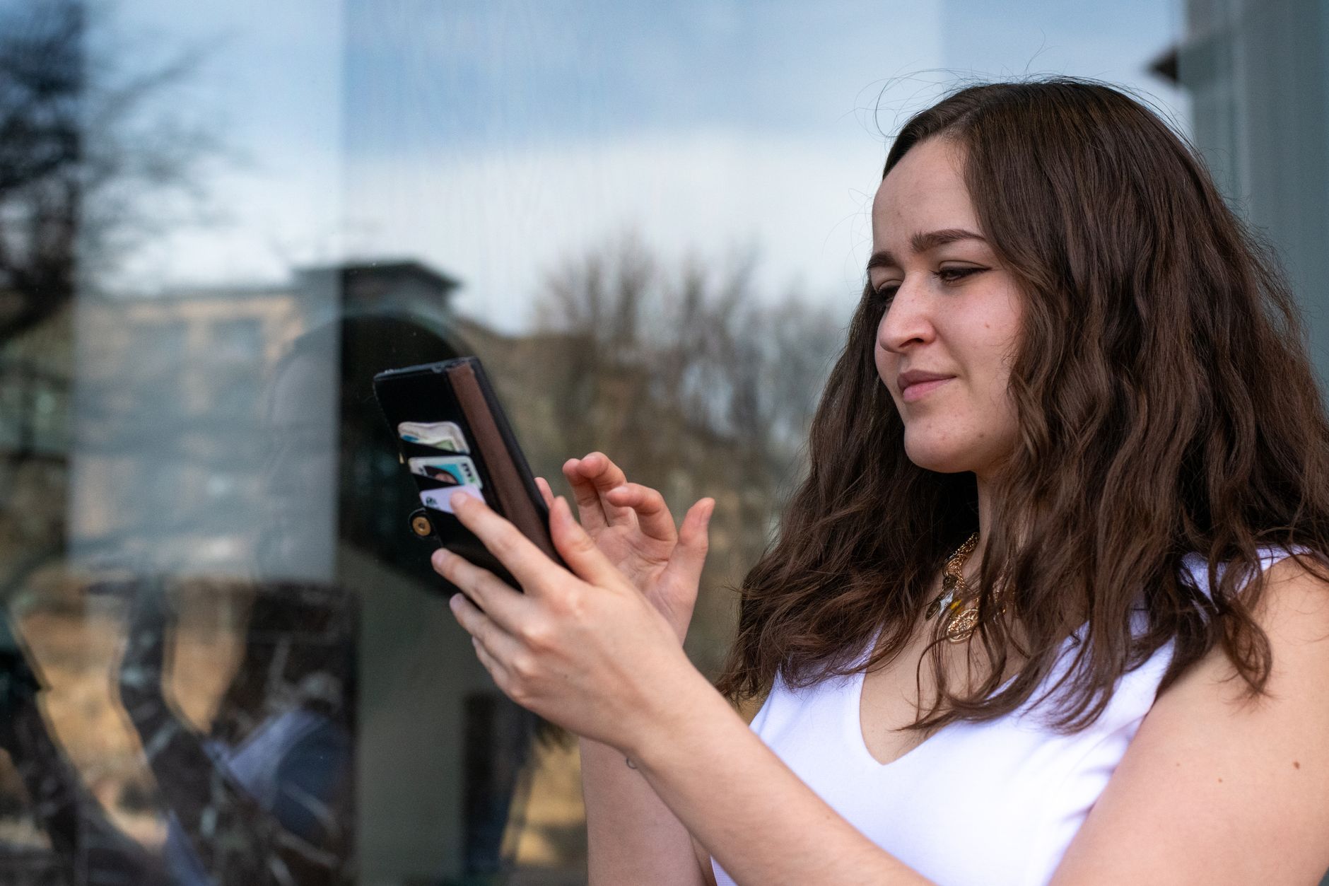 A young musician looking at a smartphone screen with blurred social media notification icons reflected in the background